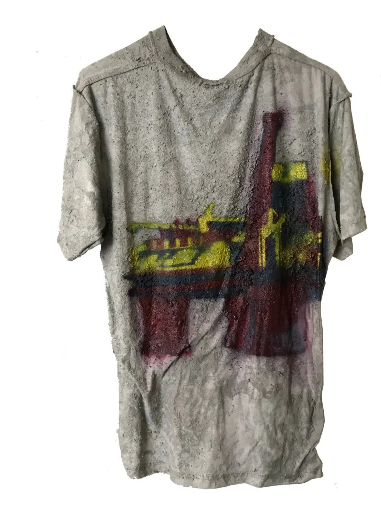 A grey T-shirt cast stiff in concrete, spray-painted with the city's skyline